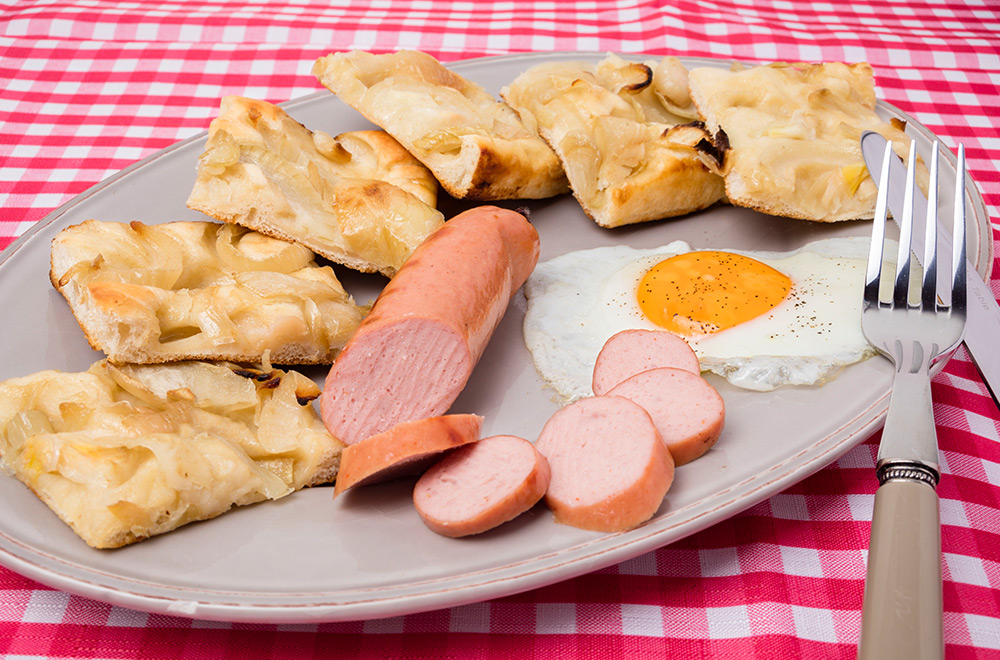 Focaccia con cipolle, uova al tegamino e wurstel, Tossini